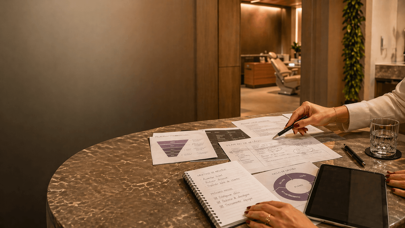 Mesa de decisão comercial dentro de uma clínica premium, com documentos, plano de ação, tablet e análise de vendas.
